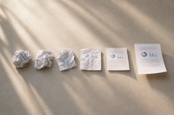 Junior Office Worker at Desk with Draft Printouts and Final Page